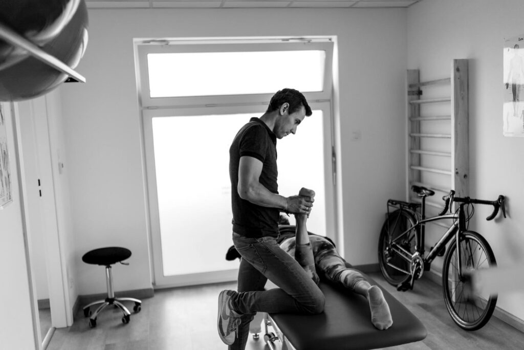 Fizjoterapeuta sprawdza ruchomość biodra pacjentki na leżance w gabinecie bike fittingu